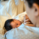 breastfeeding newborn baby in hospital ward